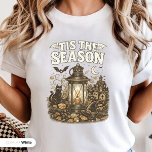 Model wearing a white shirt printed with "Haunted Harvest Lantern" across the chest.