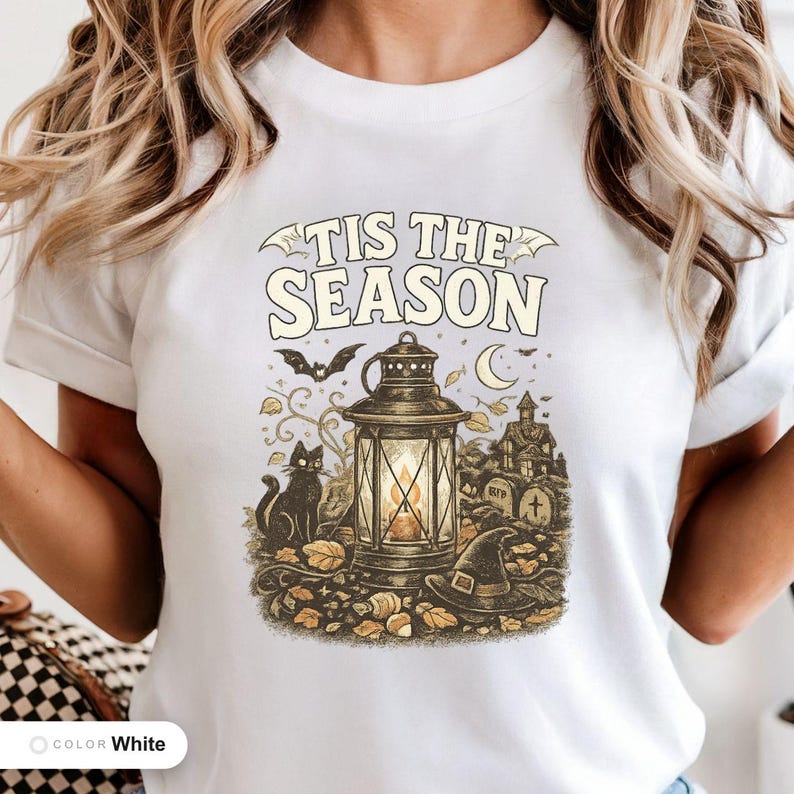 Model wearing a white shirt printed with "Haunted Harvest Lantern" across the chest.