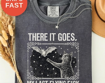 骸骨コウモリ猫グラフィックTシャツ、ハロウィンシーズンのユーモアプリント（コンフォートカラーズ）