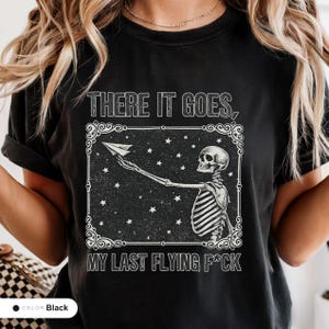 Model wearing a black t-shirt printed with "Last Nerve Bat-Free Skeleton" across the chest.