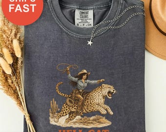 ヴィンテージ風の大胆なヘルキャットシャツ、レトロなウエスタンアニマルシャツ、おしゃれなTシャツ、斬新なユーモアプリント、快適な色合いのTシャツ、コットンカジュアルウェア