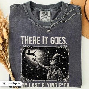 Pepper t-shirt folded flat and photographed from above, printed with "Last Flight Skeleton Bat" across the chest.