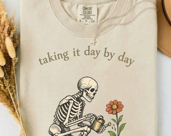 Camiseta "Take It Day by Day" (Voy al día a día) con temática de jardinería esquelética, regalo ideal para amantes de las plantas y de estilo gótico, camiseta botánica vintage, humor espeluznante sobre jardinería, estilo brujo y natural.