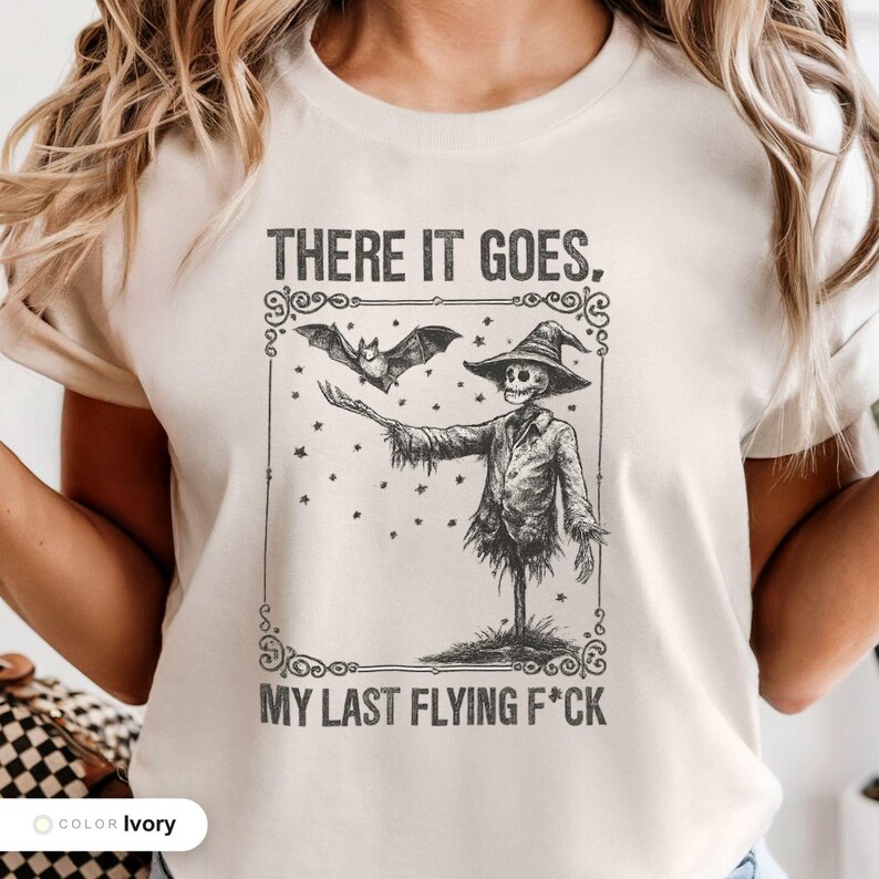 Model wearing a ivory t-shirt printed with "Graveyard Bat Catcher" across the chest.