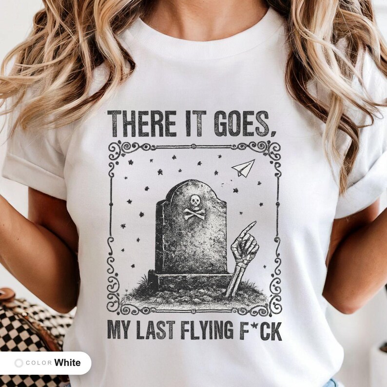 Model wearing a white t-shirt printed with "Last Flying F*ck in the Graveyard" across the chest.