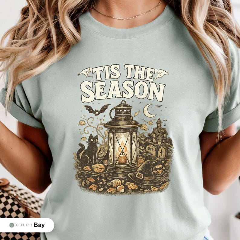Model wearing a bay shirt printed with "Haunted Harvest Lantern" across the chest.