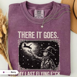 Berry t-shirt folded flat and photographed from above, printed with "Last Flight Skeleton Bat" across the chest.