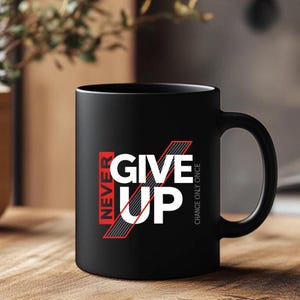 May include: Black ceramic coffee mug with the words "NEVER GIVE UP" in white and red lettering. The mug has a curved handle and the phrase "CHANGE ONLY ONCE" is printed vertically on the right side.