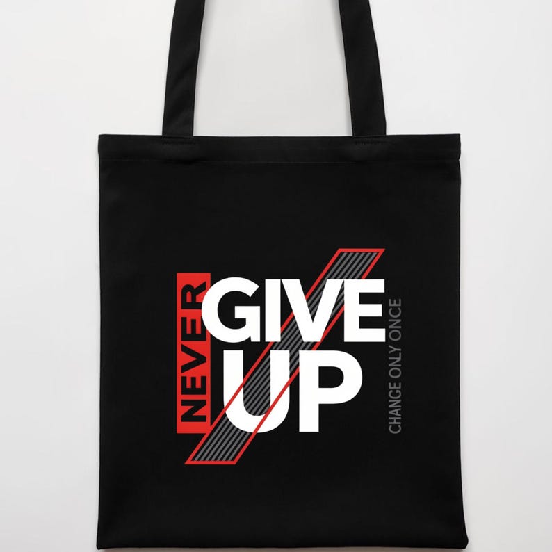 May include: Black tote bag with the words "NEVER GIVE UP" in white and red block letters. The words are set against a black background. The phrase "CHANGE ONLY ONCE" is printed vertically on the right side.