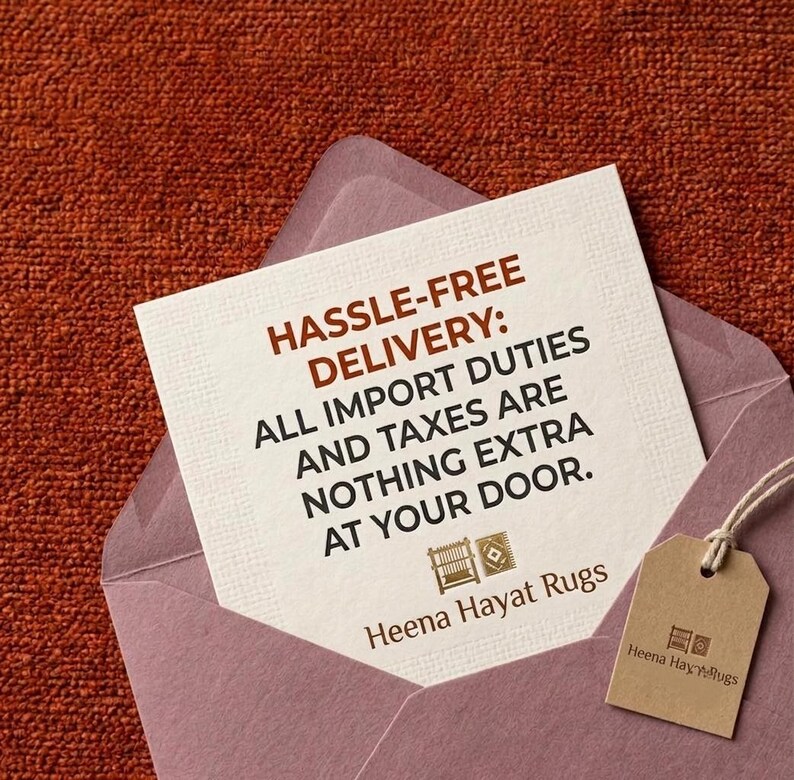 May include: A square off-white card with dark brown text reading HASSLE-FREE DELIVERY: ALL IMPORT DUTIES AND TAXES ARE NOTHING EXTRA AT YOUR DOOR. Below the text are two small icons and the brand name Heena Hayat Rugs, with a brown tag attached.