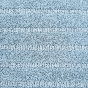 May include: Close-up of a light blue bath mat with a textured, looped pile. The mat features horizontal stripes of a lighter blue color, creating a subtle pattern. The soft, plush material suggests comfort and absorbency.