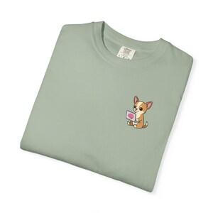 Könnte beinhalten: Salbeigrünes T-Shirt mit einer gestickten Cartoon-Chihuahua-Grafik, die einen Laptop mit einem Gehirn verwendet. Das Shirt besteht aus einem weichen, bequemen Material.
