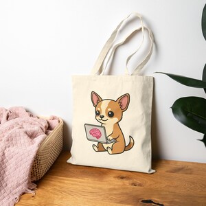 Może przedstawiać: Kremowa torba typu tote z kreskówkowym chihuahua z brązowym i brązowym futrem, siedzącym i patrzącym na laptopa. Ekran laptopa wyświetla różowy mózg. Torba ma dwa beżowe uchwyty.