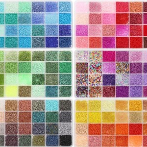 May include: A collection of colorful seed beads in a clear plastic organizer. The beads are arranged in small, square compartments, showcasing a wide array of colors including blues, greens, pinks, purples, yellows, and browns. Ideal for jewelry making and crafting.