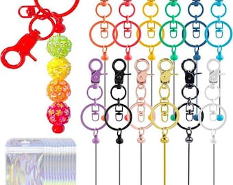 May include: A collection of colorful keychain hardware sets featuring lobster claw clasps, split rings, and long metal pins. One keychain is assembled with four glittery, textured spherical beads in green, yellow, orange, and pink. Includes clear bags.