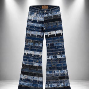 Op de afbeelding: Blauwe spijkerbroek met een patchworkontwerp bestaande uit horizontale stroken van verschillende denimwassing, waaronder lichte, medium en donkerblauwe tinten. De broek heeft een wijd uitlopend model, een knoopsluiting en een bruin leren label met TRT.