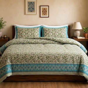 May include: A bed dressed with a floral patterned duvet cover and pillowcases. The bedding has a cream base with green and brown floral patterns, and a turquoise border. Two framed pictures are mounted above the bed.