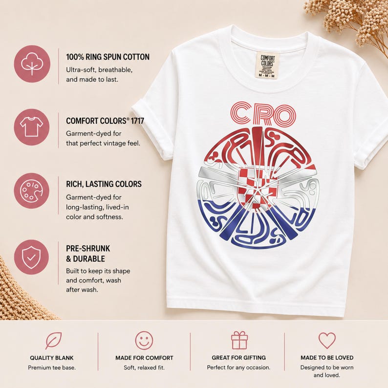 May include: A white short-sleeve t-shirt featuring a circular graphic with the text CRO above it. The graphic contains a red, white, and blue design with a checkered pattern in the center. The shirt has a Comfort Colors label at the neck.