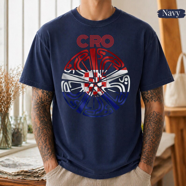 May include: A navy blue short-sleeve t-shirt featuring a circular graphic on the chest. The design incorporates the red, white, and blue colors of the Croatian flag with a checkered pattern and the text CRO in red letters above the circle.