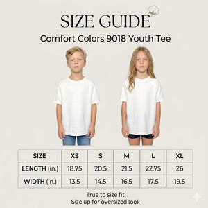 May include: A size guide for the Comfort Colors 9018 youth tee featuring two children wearing white t-shirts. A table displays length and width measurements in inches for sizes XS through XL, ranging from 18.75 to 26 inches in length.