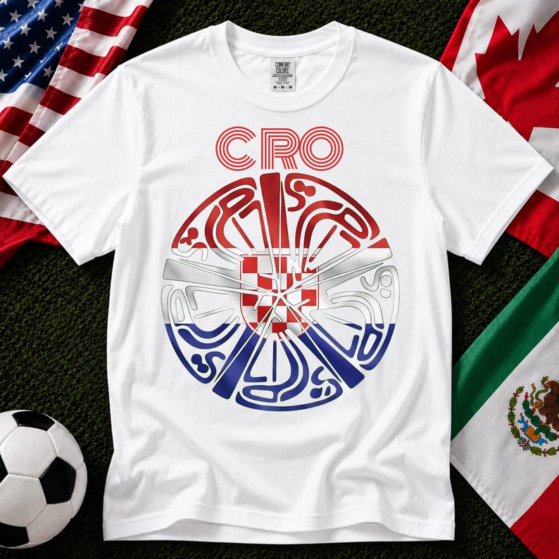 May include: A white short-sleeve t-shirt featuring a circular graphic design with the text CRO at the top. The center of the circle displays the red and white checkered pattern of the Croatian flag, surrounded by stylized blue and red line art.