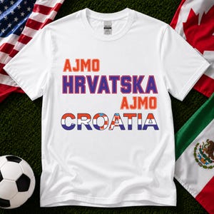 May include: A white short-sleeved t-shirt featuring the orange text AJMO, the purple text HRVATSKA, the orange text AJMO, and the word CROATIA in blue, with the letters filled with a red, white, and blue checkered pattern.