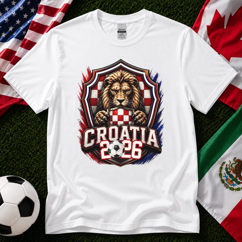 May include: White t-shirt featuring a lion graphic holding a Croatian checkered emblem. The design includes the text "CROATIA 2026" and a soccer ball. The shirt is surrounded by red, white, and blue accents.