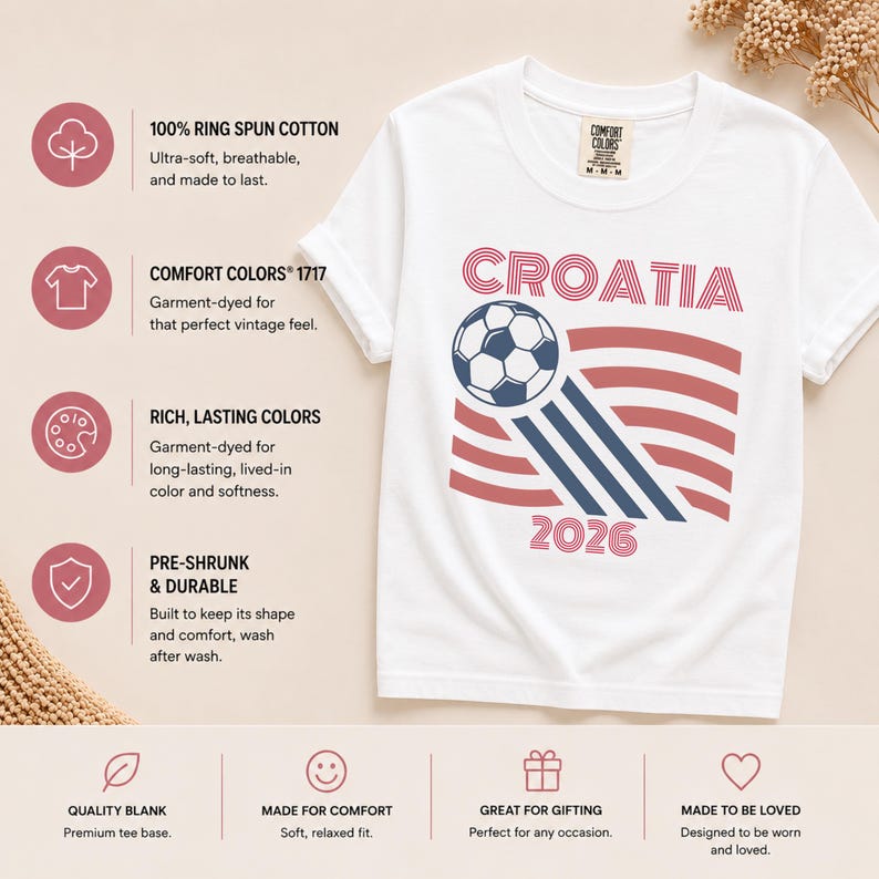 May include: A white short-sleeve t-shirt featuring a graphic of a soccer ball and red wavy stripes with the text "CROATIA" and "2026". The shirt includes a Comfort Colors brand tag at the neck and is displayed with informational text icons.