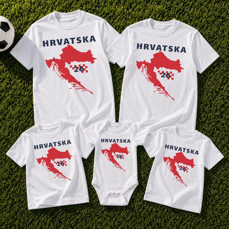 Op de afbeelding: Een collectie witte T-shirts met korte mouwen en &eacute;&eacute;n witte romper met korte mouwen, elk voorzien van een rode kaart van Kroati&euml;, de tekst HRVATSKA in donkerblauw en een klein rood-wit geblokt vierkant met het nummer 26 op de voorzijde.