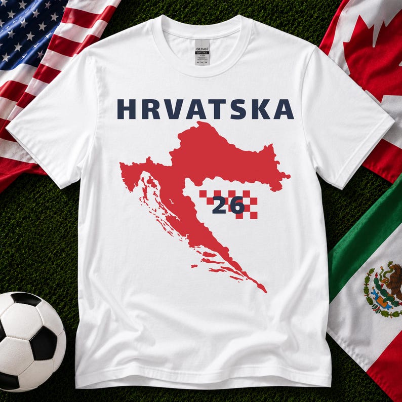 Op de afbeelding: Een wit T-shirt met korte mouwen met de tekst HRVATSKA in donkerblauwe letters boven een rode kaart van Kroati&euml;. De kaart bevat een rood-wit geblokt patroon met het getal 26 in het donkerblauw gecentreerd over het geblokte ontwerp.