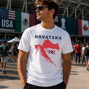 Op de afbeelding: Een wit T-shirt met korte mouwen voorzien van de tekst HRVATSKA in donkerblauwe letters boven een rode kaart van Kroati&euml;. De kaart bevat een rood-wit geblokt patroon met het cijfer 26 in het donkerblauw in het onderste deel van de afbeelding.