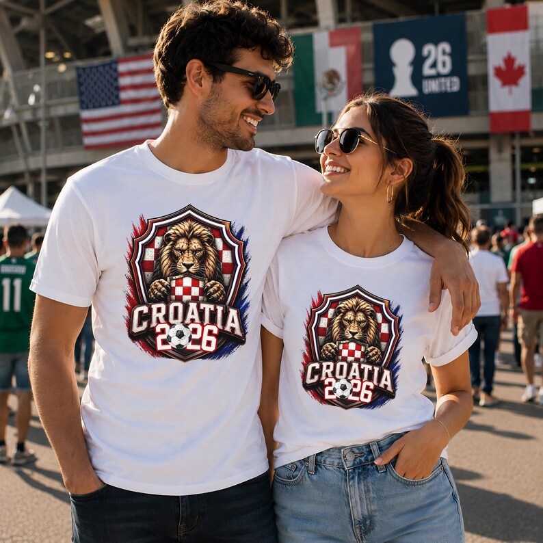 May include: White t-shirts with a Croatia 2026 design. The design features a lion holding a soccer ball within a shield, with red, white, and blue accents. The shirts are worn by a couple, suggesting a theme of sports or team spirit.
