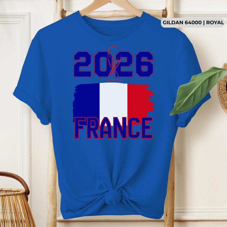 May include: Royal blue t-shirt featuring the text "2026 FRANCE" in red and white, with a stylized French flag design. The shirt is made of a soft material and has short sleeves.