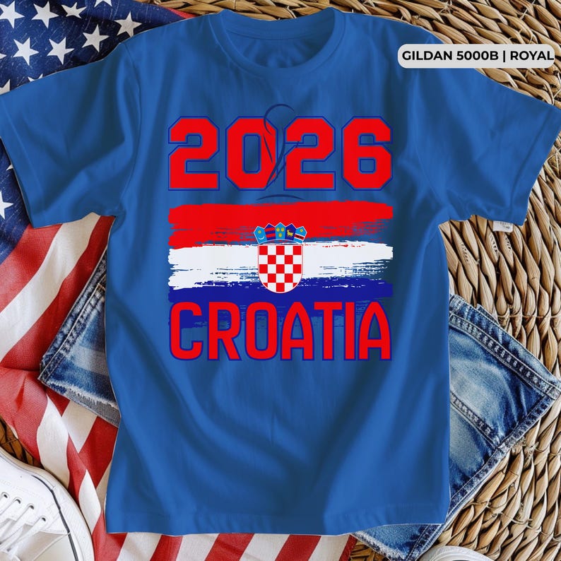 May include: Royal blue t-shirt with the text "2026 CROATIA" in red. The design includes a red, white, and blue brushstroke with the Croatian coat of arms. The shirt is a Gildan 5000B.