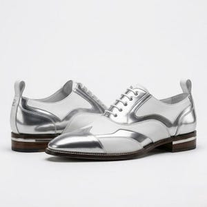 Könnte beinhalten: Ein Paar weiße und metallic-silberne Oxford-Schuhe mit Flügelkappe, weißen Schnürsenkeln und einem gestapelten Holzabsatz mit silbernem Zierstreifen. Die Schuhe haben eine spitz zulaufende Kappe und eine Zuglasche an der Fersenkappe.