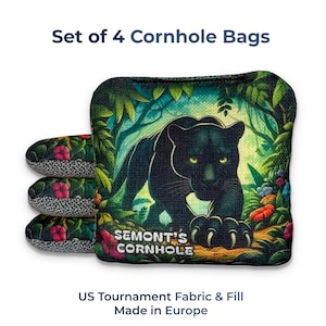May include: Set of four cornhole bags. One bag features a black panther illustration in a jungle setting, with the text "SEMONT'S CORNHOLE." The other bags have a floral pattern. The text "US Tournament Fabric & Fill Made in Europe" is also present.
