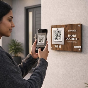 May include: A person scans a QR code on a smartphone, mirroring a QR code on a wooden smart doorbell. The doorbell has the text "Lifecode SMART DOORBELL Welcomes You!" and "SCAN ME". The doorbell is mounted on a light-coloured wall.