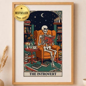 May include: A framed wall art print titled THE INTROVERT featuring a skeleton sitting in an orange armchair reading a book. The scene includes bookshelves, a side table with a cup and candle, and a night sky with a crescent moon and stars.