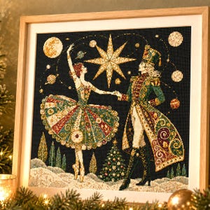 May include: A framed cross-stitch embroidery depicting a ballerina and a nutcracker soldier dancing against a dark blue starry sky. The scene features a large central star, planets, a decorated Christmas tree, and a snowy landscape below.