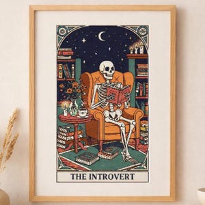 May include: Framed art print depicting a skeleton reading a book in an armchair. The scene includes a bookshelf, flowers, a table with a cup and candle, and the text "THE INTROVERT" at the bottom. The background shows a starry night with a crescent moon.