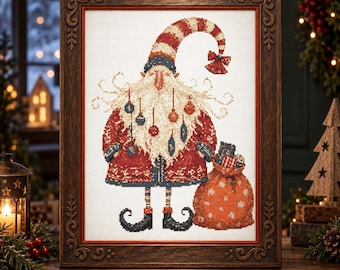 May include: A framed cross-stitch artwork depicting a stylized Santa Claus figure with a long white beard adorned with hanging ornaments, wearing a red patterned coat, striped hat, and dark curled shoes, holding a large red sack of gifts.