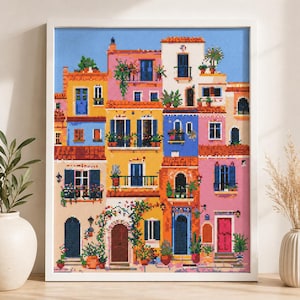 May include: A framed cross-stitch artwork depicting a colorful village scene. The buildings are in shades of pink, yellow, blue, and orange, with detailed windows, doors, and balconies. Potted plants and flowers add to the vibrant aesthetic.
