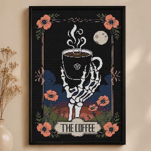 May include: Framed art print featuring a black background with a skeleton hand holding a coffee cup. The cup has steam rising from it. The print includes the text "THE COFFEE" and is decorated with orange flowers and a moon.