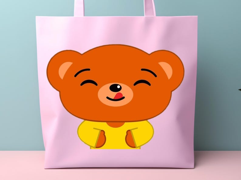 May include: A light pink tote bag featuring a cartoon bear face. The bear has orange fur, a yellow shirt, and a black nose and eyes. The bear's tongue is sticking out. The tote bag has pink handles.