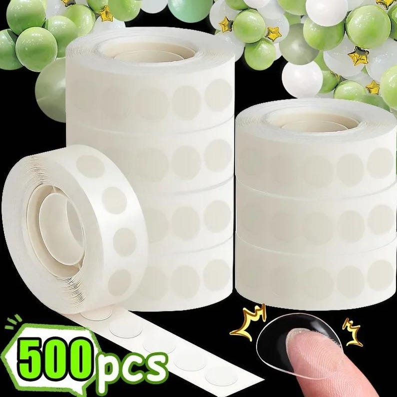 Puede incluir: Se muestran varios rollos de puntos adhesivos transparentes para globos, con una tira de puntos desenrollada. La imagen incluye el texto "500pcs" en un cuadro verde y blanco. Globos en tonos verdes y blancos est&aacute;n en el fondo.