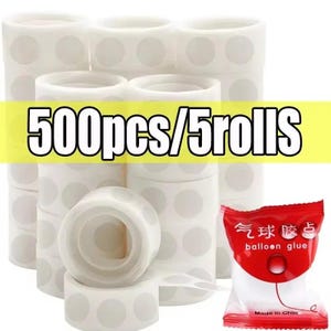Puede incluir: Varios rollos de puntos adhesivos blancos con puntos grises y un peque&ntilde;o paquete rojo de pegamento para globos. El texto "500pcs/5rolls" se muestra en una pancarta amarilla. El paquete de pegamento para globos contiene texto chino.