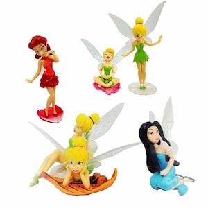 K&ouml;nnte beinhalten: Eine Sammlung von f&uuml;nf Feenfiguren in verschiedenen Posen. Die Feen tragen farbenfrohe Kleider und haben durchscheinende Fl&uuml;gel. Eine Fee tr&auml;gt ein rotes Kleid, eine andere ein gr&uuml;nes Kleid und eine dritte ein blaues Kleid. Auf wei&szlig;em Hintergrund.