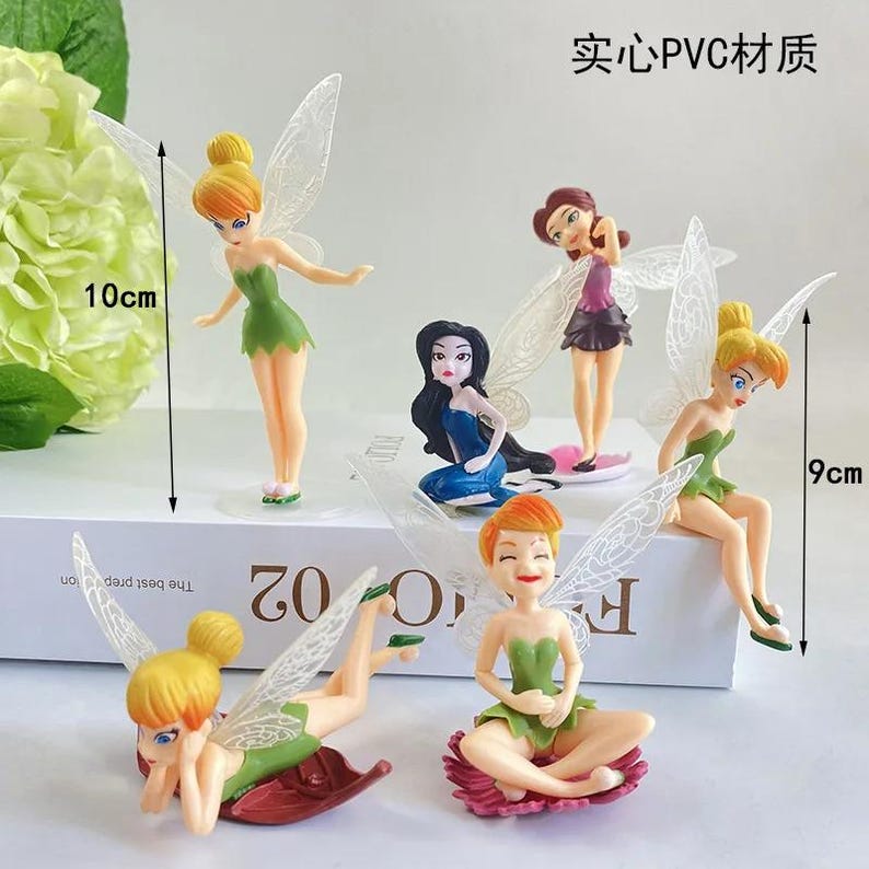 K&ouml;nnte beinhalten: Eine Sammlung von sechs Feenfiguren mit durchscheinenden Fl&uuml;geln. Die Feen sind in verschiedenen Posen und tragen Kleider in Gr&uuml;n-, Blau- und Lilat&ouml;nen. Die gr&ouml;&szlig;te Figur ist 10 cm gro&szlig;, die kleinste 9 cm. Der Text "实心PVC材质" ist sichtbar.