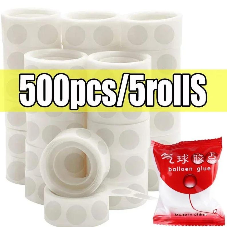 Puede incluir: Apilados de rollos de puntos adhesivos blancos con c&iacute;rculos grises, y un peque&ntilde;o paquete rojo y blanco de pegamento para globos. El texto "500pcs/5rolls" se muestra sobre un fondo amarillo.