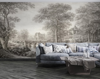 May include: A grayscale mural depicting a classical landscape with trees, a bridge, and a castle. A gray sectional sofa with patterned pillows and a wooden coffee table are in front of the mural.